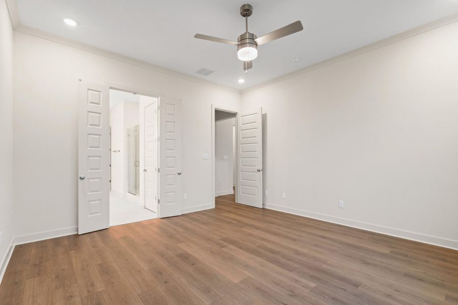 Spacious room featuring wood-finish flooring, recessed lighting, and a contemporary ceiling fan Spacious room featuring wood-finish flooring, recessed lighting, and a contemporary ceiling fan