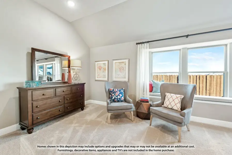 Bedroom sitting area with vaulted ceiling, two gray chairs, wood dresser with mirror, and large windows Bedroom sitting area with vaulted ceiling, two gray chairs, wood dresser with mirror, and large windows