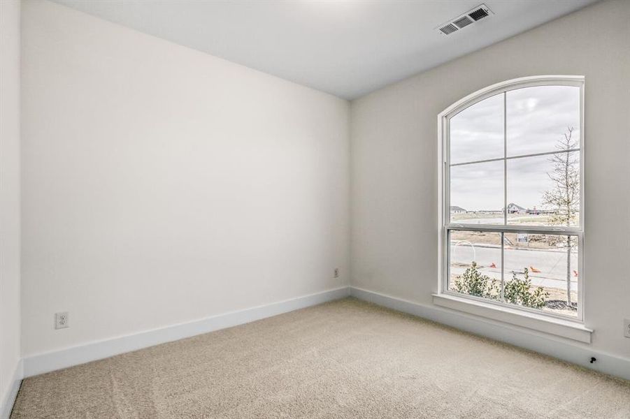 Unfurnished room featuring light carpet and baseboards