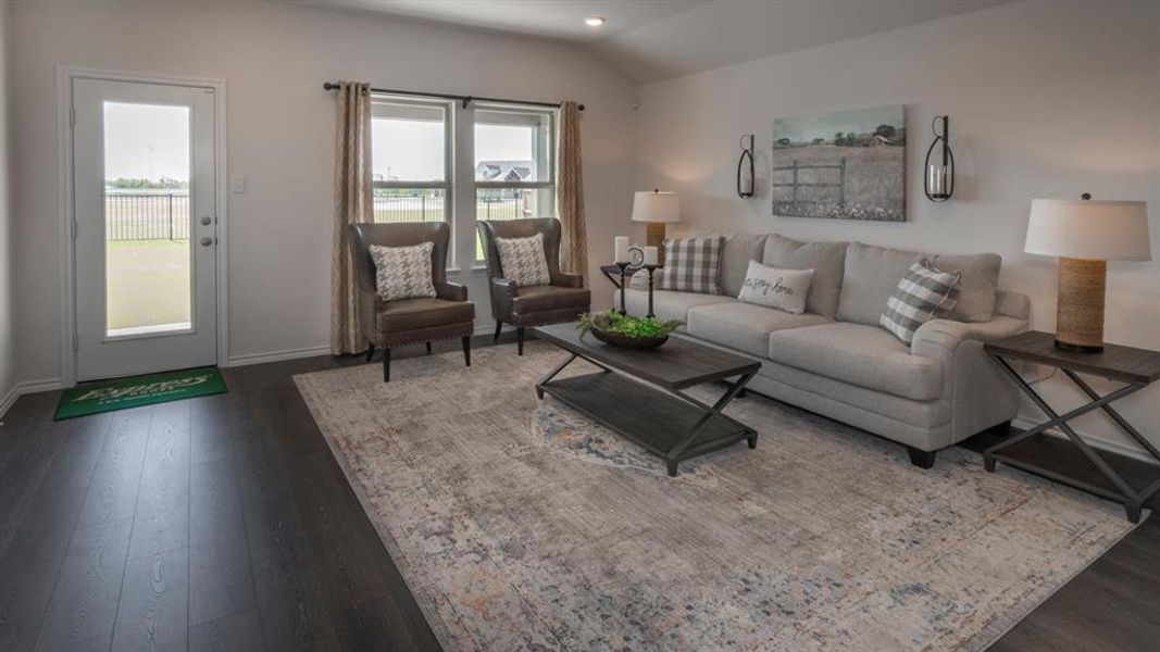 Living room featuring dark wood-type flooring, lofted ceiling, and recessed lighting