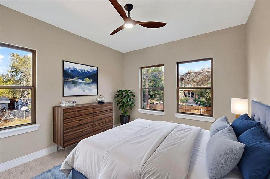 Carpeted bedroom with a ceiling fan and baseboards