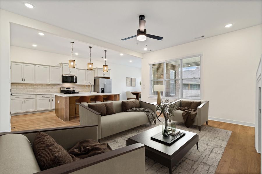 Open-concept living space featuring wood-finish flooring, recessed lighting, and a modern ceiling fan Open-concept living space featuring wood-finish flooring, recessed lighting, and a modern ceiling fan