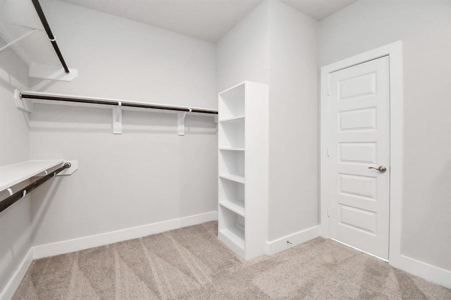 Step into a walk-in closet that defines luxury and functionality. This generously sized space boasts built-in shelving, providing ample room for organization.