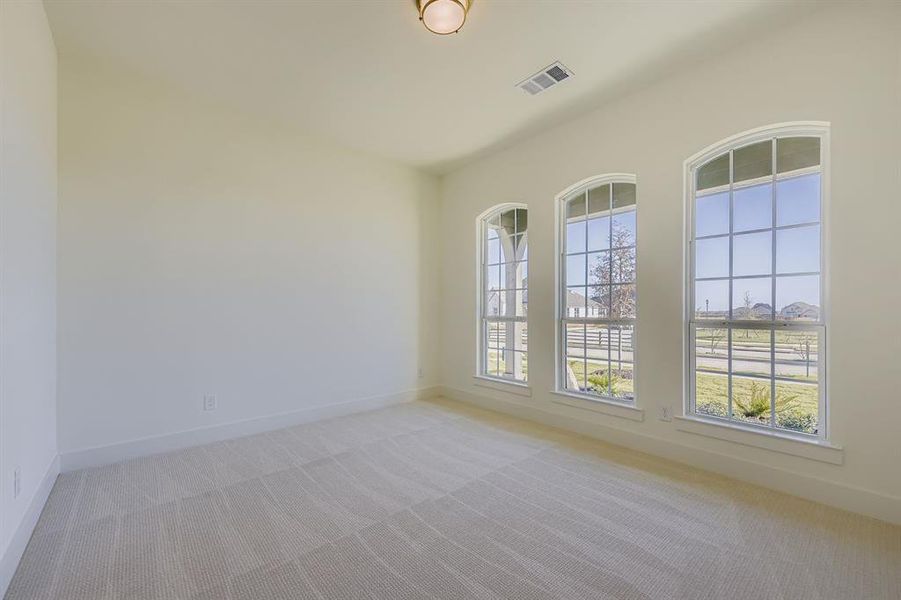 Empty room with light colored carpet and baseboards