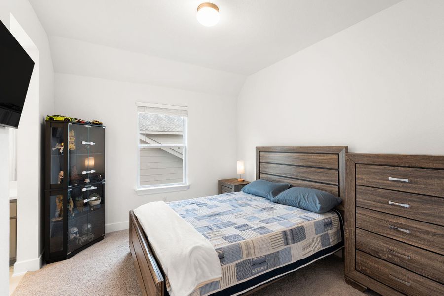 A well-lit bedroom offering a cozy, inviting atmosphere with ample natural light.
