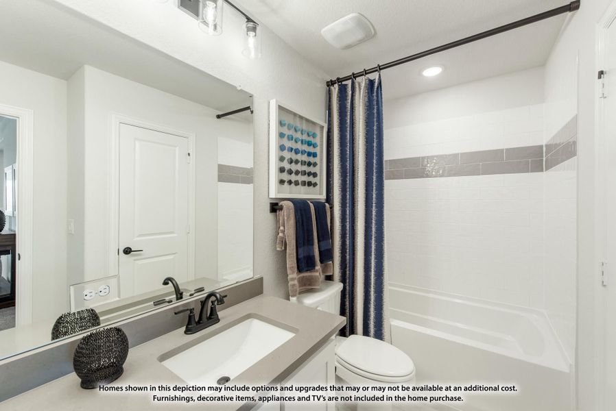 Bathroom with gray countertop vanity, large mirror, and tub-shower combo with white tile and gray accent strip.