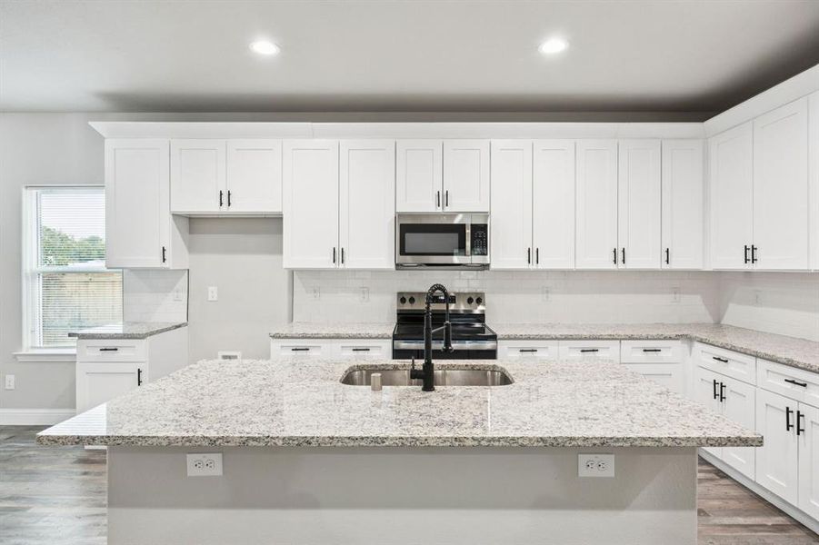 Kitchen featuring dark wood finished floors, appliances with stainless steel finishes, white cabinetry, and recessed lighting Kitchen featuring dark wood finished floors, appliances with stainless steel finishes, white cabinetry, and recessed lighting