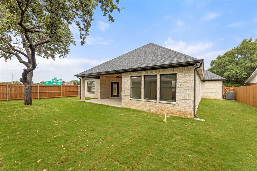 Rear view of property featuring a lawn,