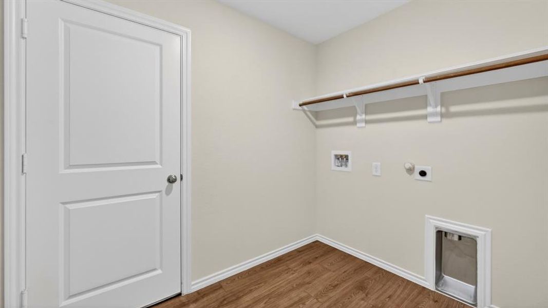 Utility area featuring wood-finish flooring, light neutral wall paint, and a white two-panel door