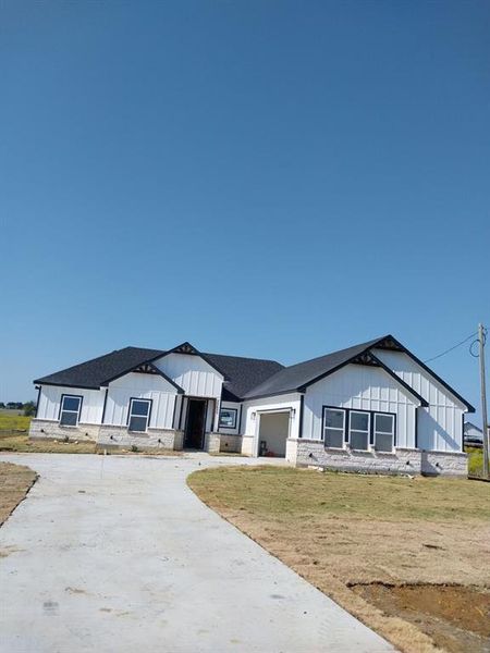 View of front of property featuring a garage and a front lawn