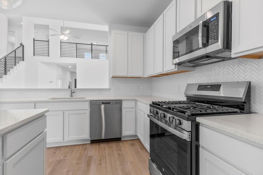 Sleek stainless steel appliances, including a gas range, framed by stunning granite countertops and abundant cabinetry — call now to make this your dream kitchen! **Image Representative of Plan Only and May Vary as Built**.