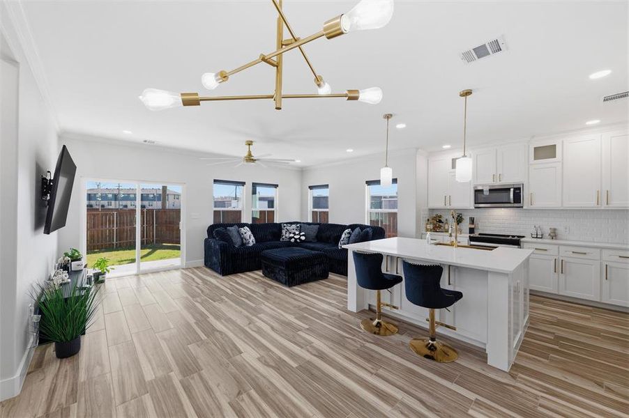 Living room featuring light wood-style flooring, a ceiling fan, and recessed lighting