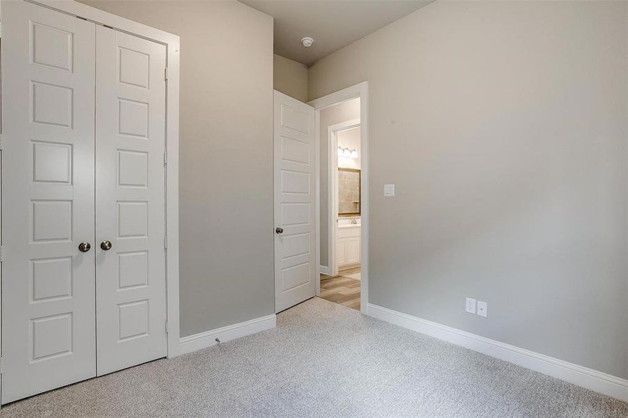 Unfurnished bedroom featuring a closet and light colored carpet