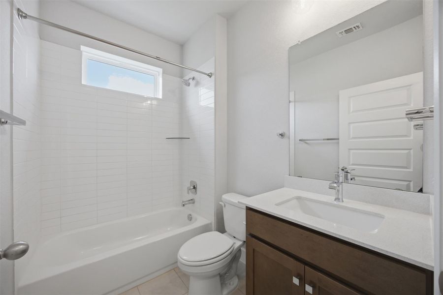 Modern bath with pristine white tiles and ample light.