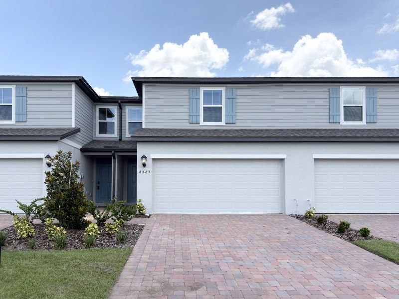 Front exterior of a new home in The Meadow at Crossprairie Townes, St. Cloud, FL, highlighting curb appeal (Image 1). Front exterior of a new home in The Meadow at Crossprairie Townes, St. Cloud, FL, highlighting curb appeal (Image 1).