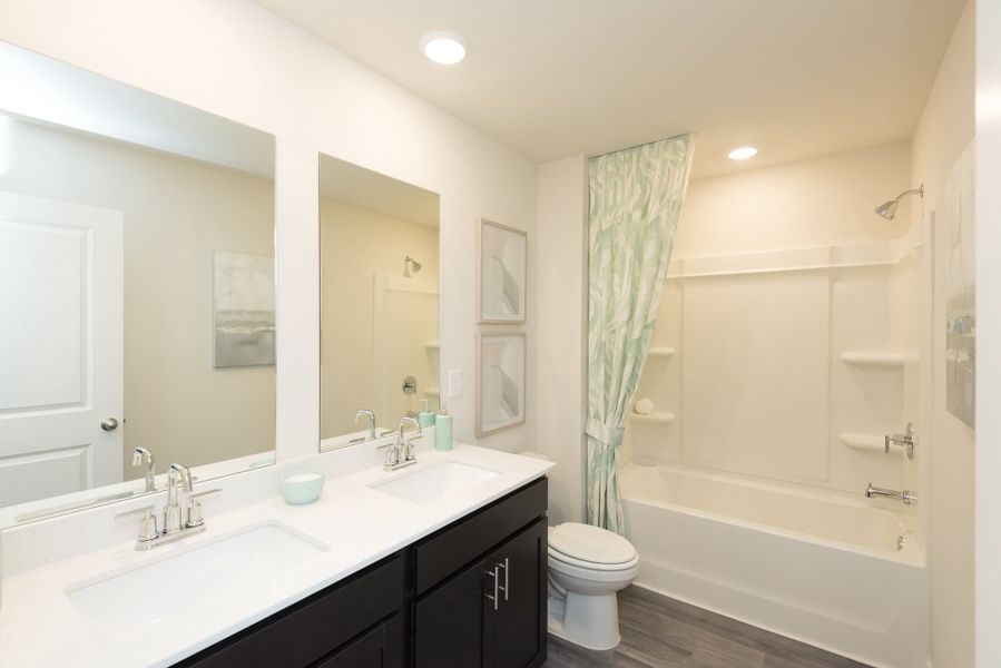 A full upstairs bathroom with dual-vanity sinks makes getting ready a breeze.