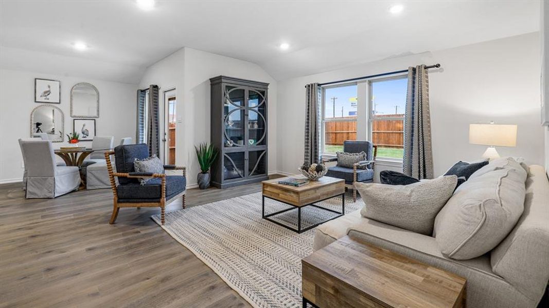 Living room with lofted ceiling, recessed lighting, and wood finished floors Living room with lofted ceiling, recessed lighting, and wood finished floors