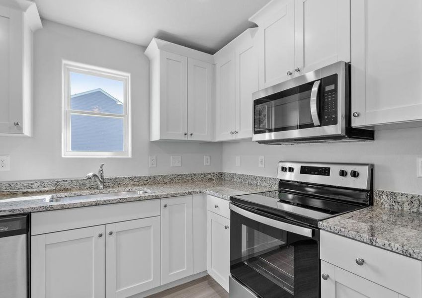 White cabinets and granite countertops in the kitchen.