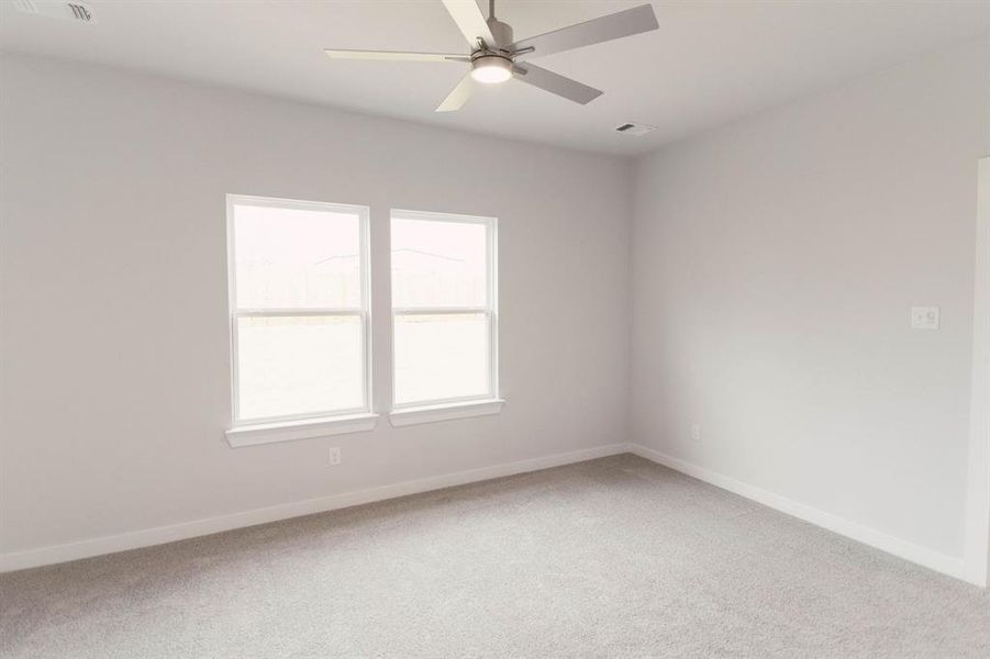 Spare room featuring carpet flooring and ceiling fan