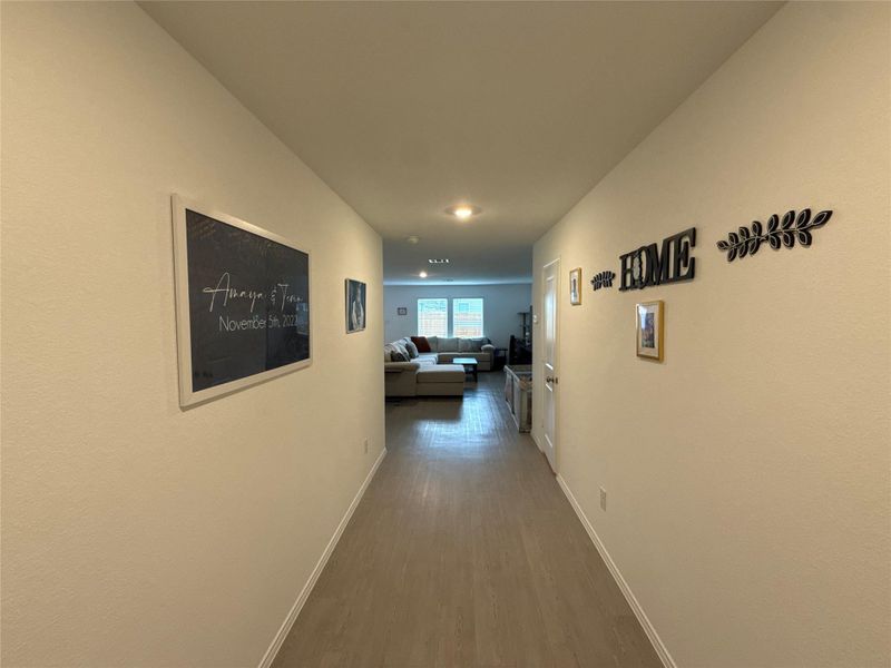 Hallway featuring light-toned wood-finish flooring, recessed lighting, and crisp white walls