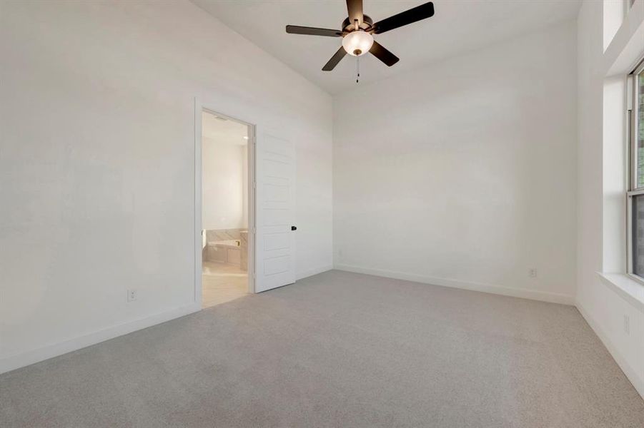 Empty room featuring light colored carpet and a ceiling fan Empty room featuring light colored carpet and a ceiling fan