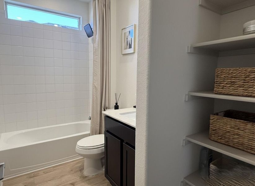 Full bathroom featuring vanity, light wood-style floors, and shower / bath combo with shower curtain