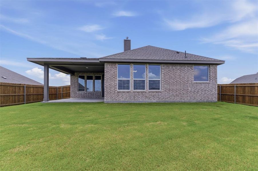 Expansive backyard featuring a manicured lawn, full privacy fencing, and a covered patio Expansive backyard featuring a manicured lawn, full privacy fencing, and a covered patio