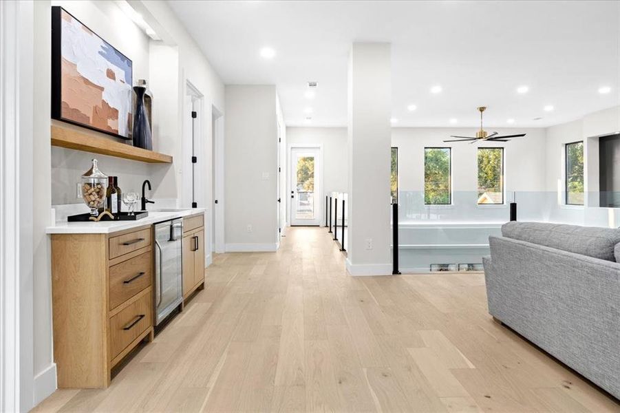 Kitchen featuring wine cooler, light wood-type flooring, and ceiling fan