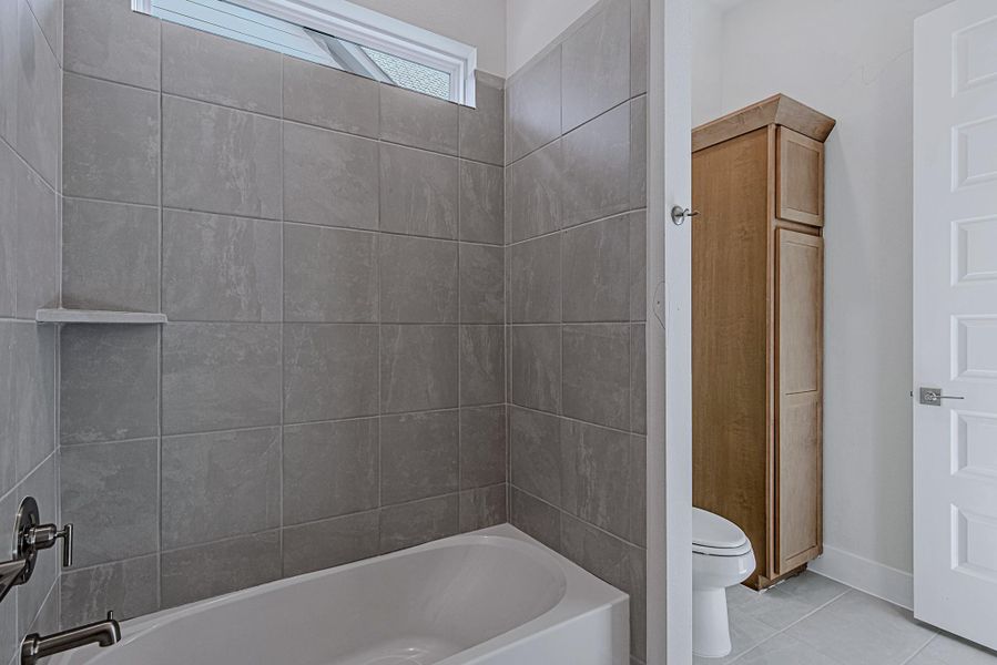 Bathroom featuring tile surround and modern fixtures.