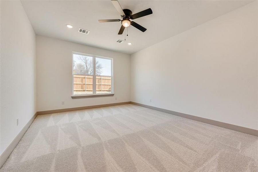 Carpeted spare room featuring ceiling fan