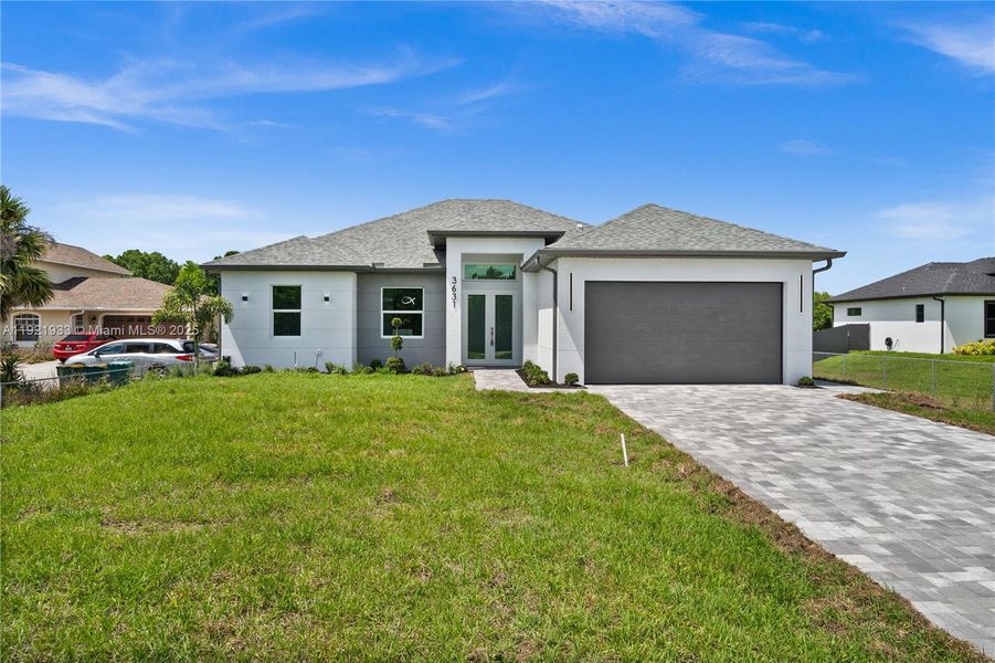 Prairie-style house with decorative driveway, agarage, stucco siding, and roof with shingles Prairie-style house with decorative driveway, agarage, stucco siding, and roof with shingles