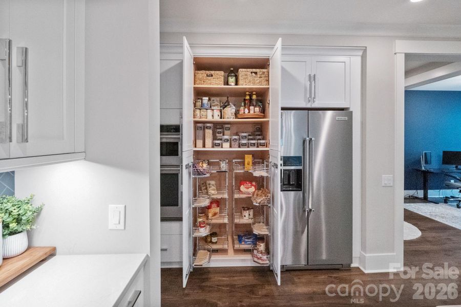Hidden pantry has custom shelving for extra storage!