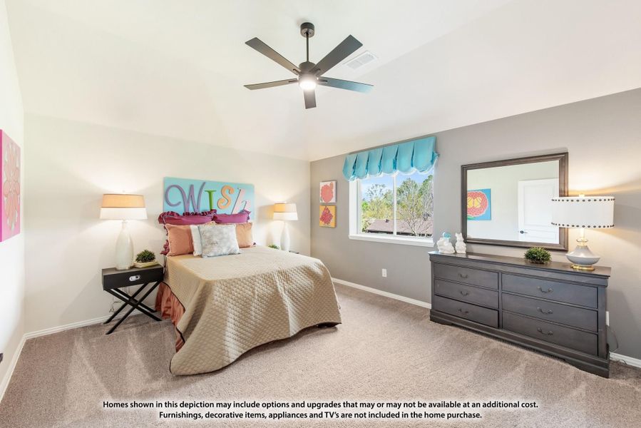 Bedroom with carpet, ceiling fan, dresser with mirror, and colorful wall art above the bed