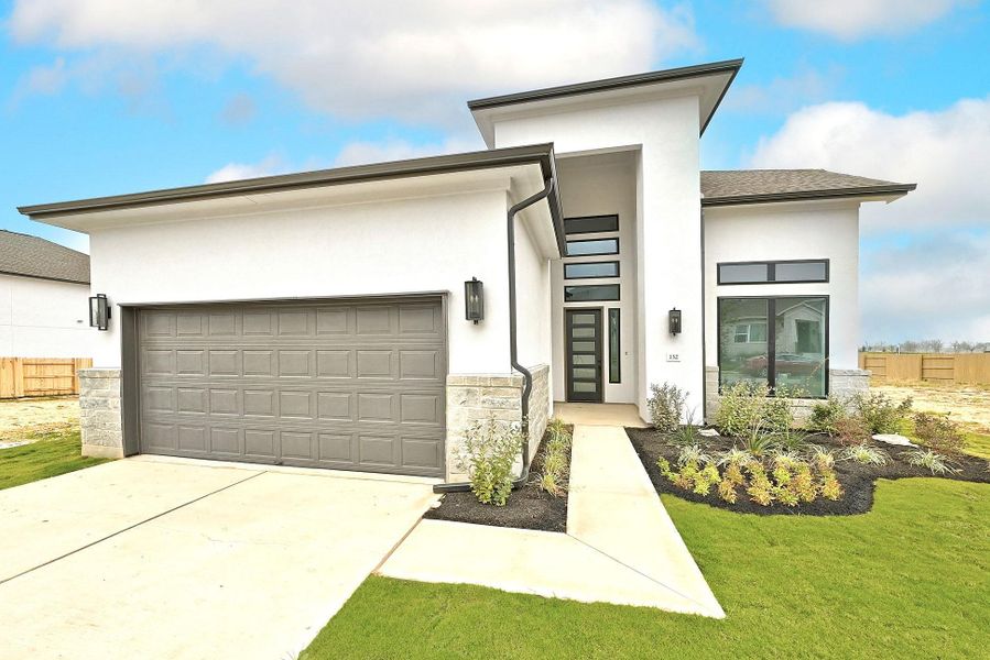 Front exterior of a new home in The Colony, Bastrop, TX, highlighting curb appeal (Image 23).