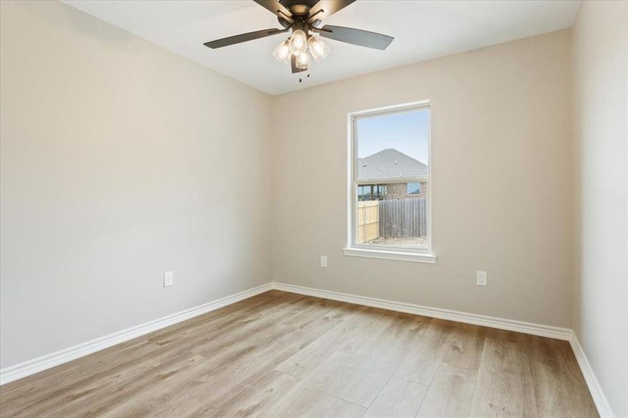 Spare room featuring light wood-type flooring, healthy amount of natural light, and a ceiling fan Spare room featuring light wood-type flooring, healthy amount of natural light, and a ceiling fan