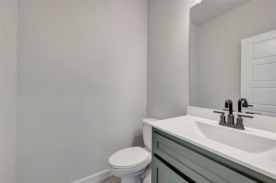 Half bathroom featuring vanity and toilet Half bathroom featuring vanity and toilet