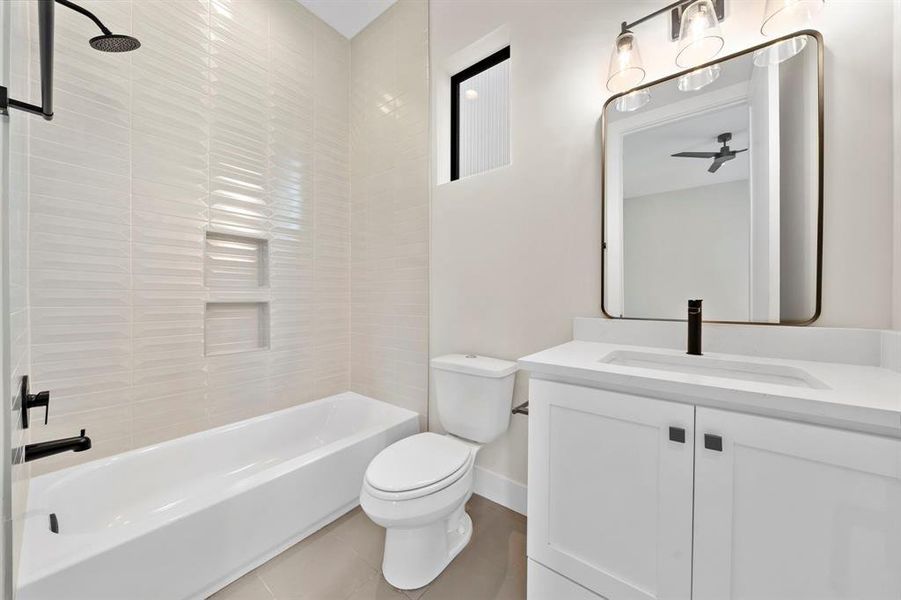 Black fixtures, product niches, and modern mirrors continue in this bath.