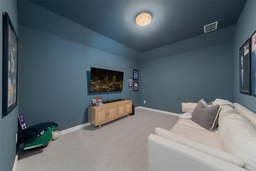 Living area with light colored carpet, visible vents, and baseboards