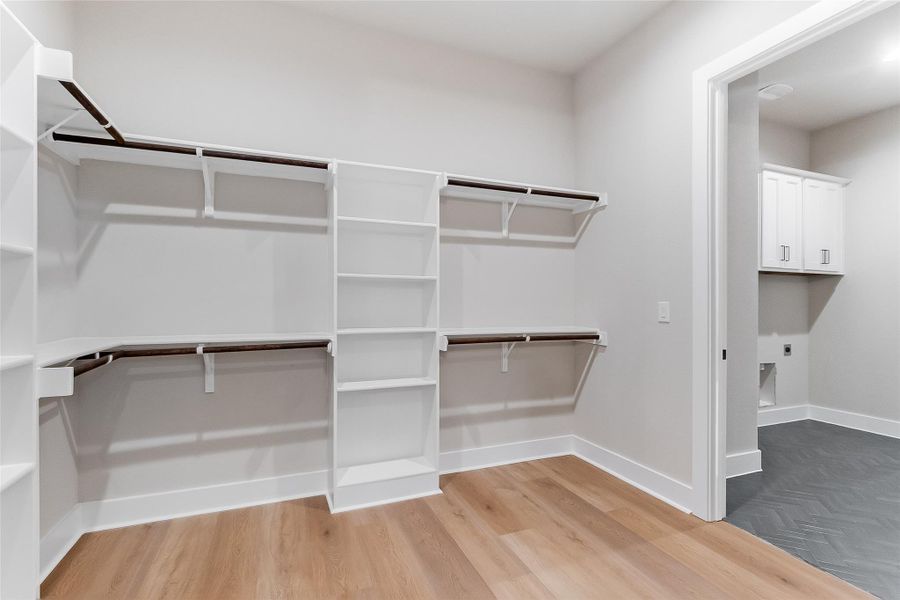 Walk in closet with light wood-style flooring