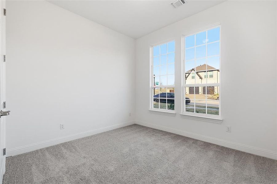 Spare room featuring carpet floors and baseboards