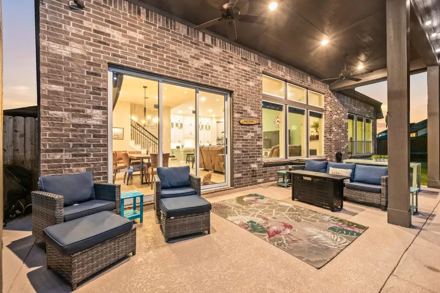 This inviting covered patio offers the perfect extension of your living space, complete with recessed lighting, ceiling fans, and a durable finished floor. Large sliding glass doors and expansive windows create a seamless indoor-outdoor flow, ideal for relaxing evenings or entertaining guests while enjoying the view of the backyard.