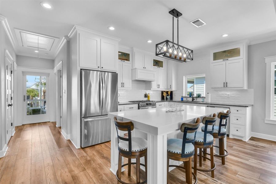 Island with quartz countertops and breakfast bar provides additional seating