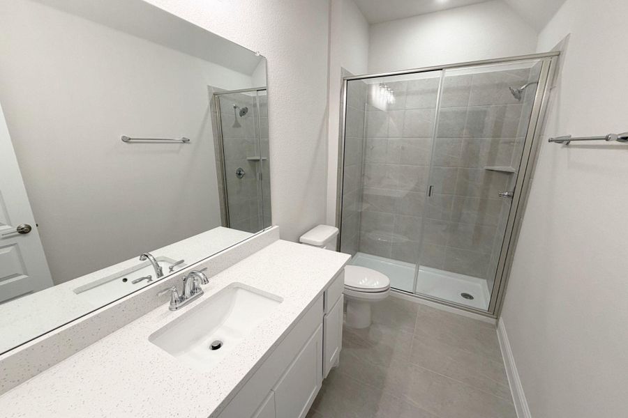 Bathroom featuring vanity, a stall shower, and light tile patterned floors