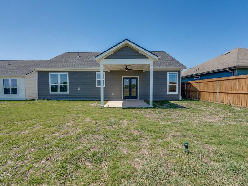 Back of property with fence, ceiling fan, french doors, a patio, and a lawn