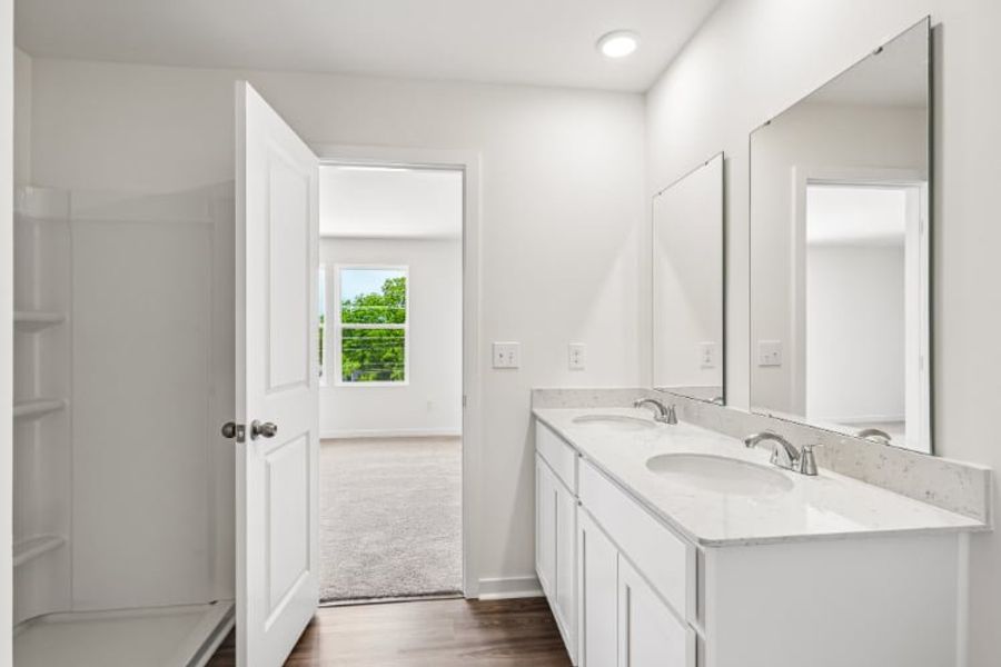 A bathroom with white cabinets.