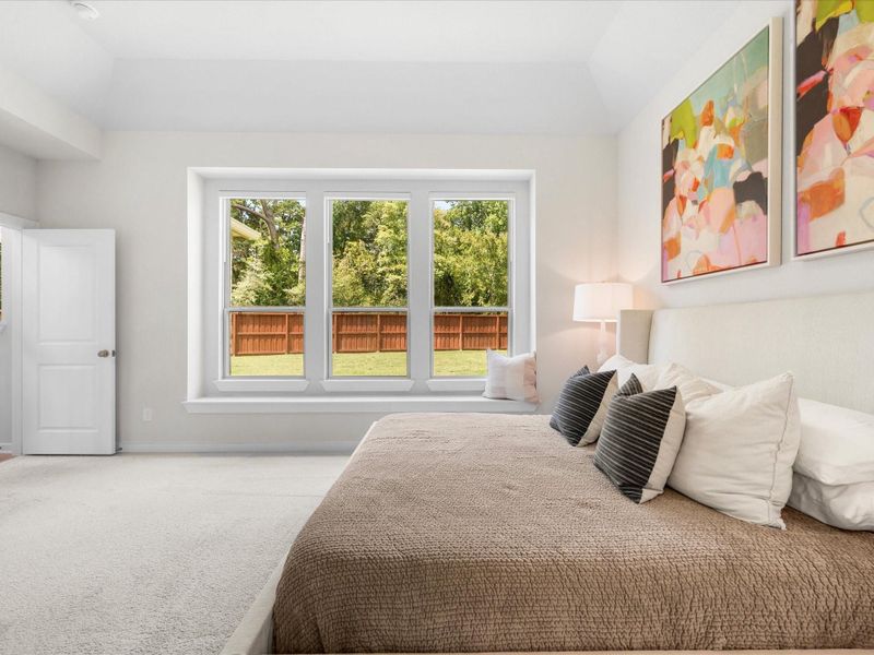 Another angle of the primary bedroom with view out windows