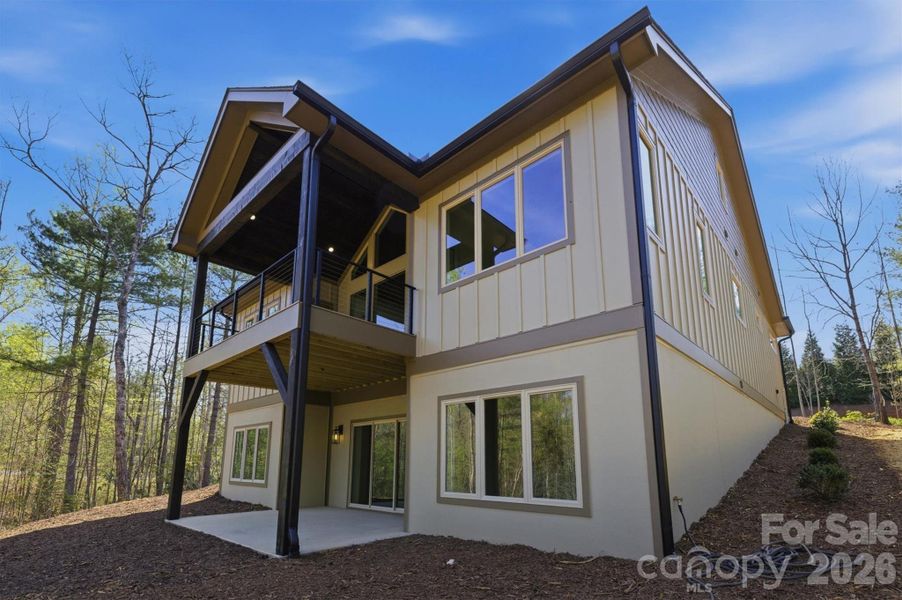 The rear elevation showcases the main level covered deck with its vaulted ceiling and the walk-out level patio for outdoor living areas from both levels of the home. The windows are Jeld-Wen Premium Vinyl windows, and there are a lot of them giving all the rooms spectacular outdoor views. The rear elevation showcases the main level covered deck with its vaulted ceiling and the walk-out level patio for outdoor living areas from both levels of the home. The windows are Jeld-Wen Premium Vinyl windows, and there are a lot of them giving all the rooms spectacular outdoor views.