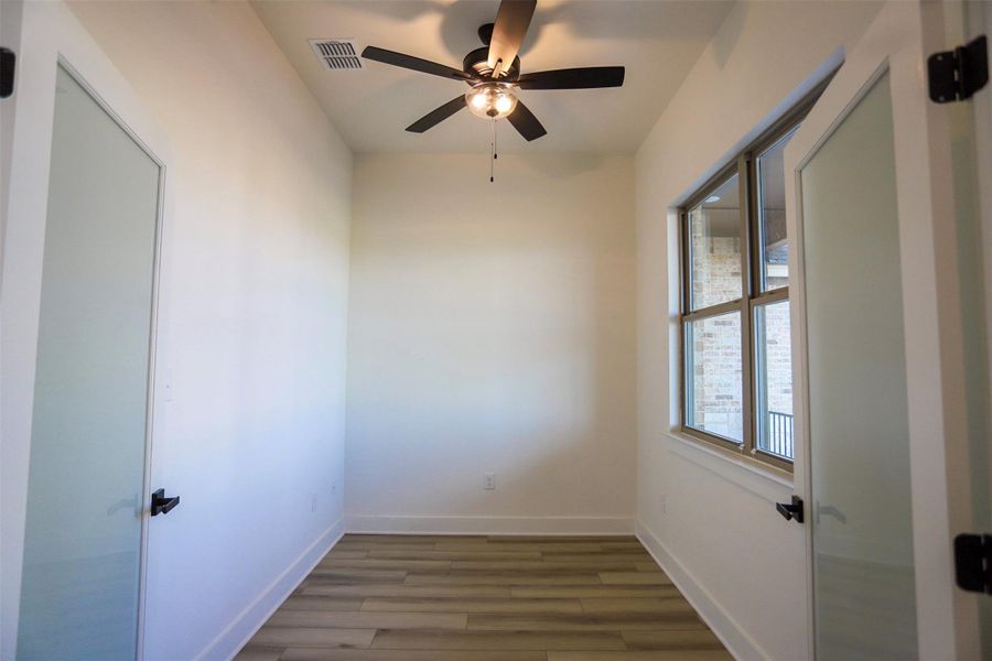 Empty room with a ceiling fan and wood finished floors