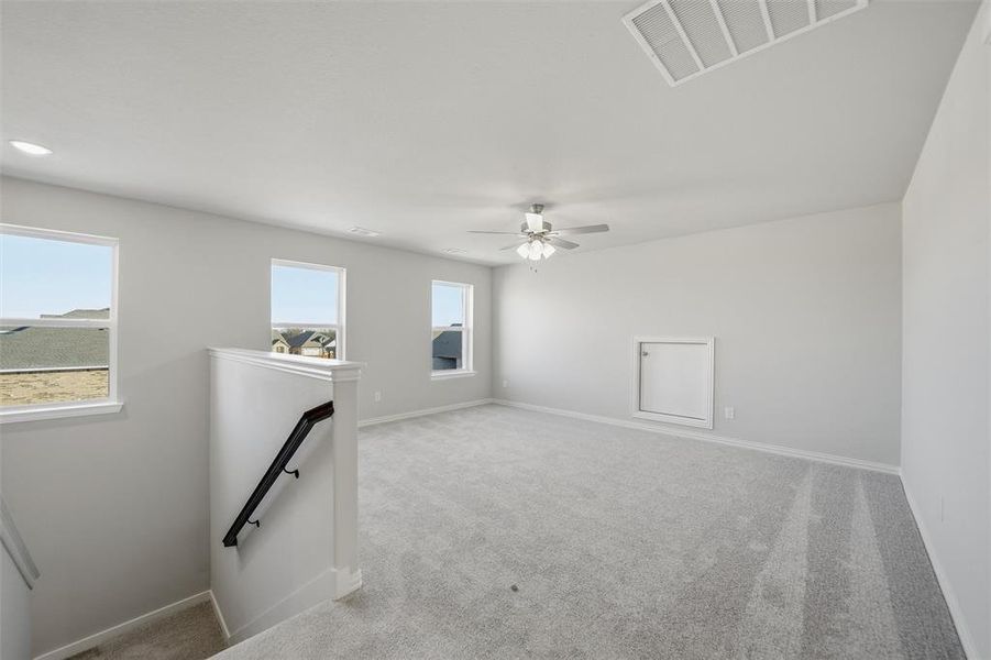 Unfurnished room with light colored carpet and a ceiling fan Unfurnished room with light colored carpet and a ceiling fan