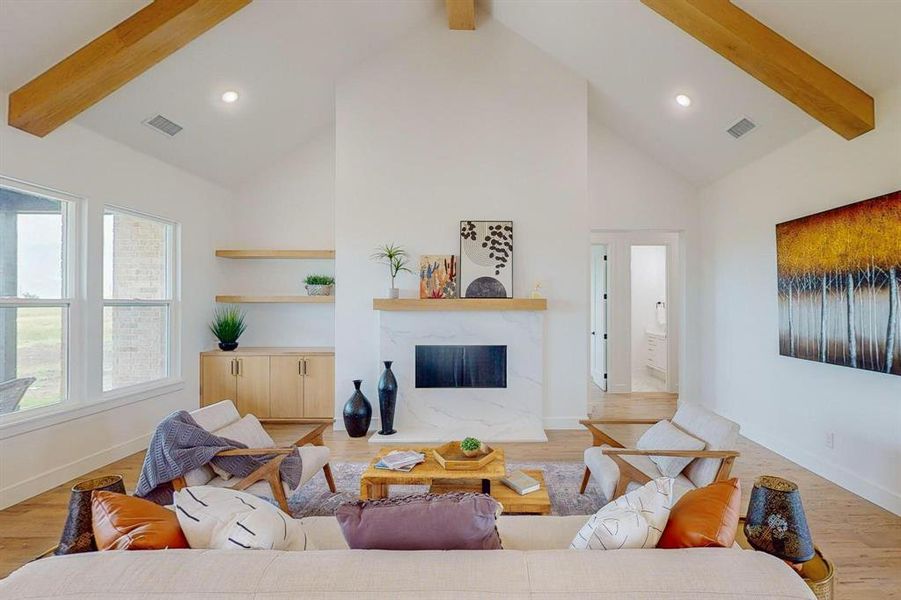 Living room with light hardwood / wood-style flooring, beamed ceiling, high vaulted ceiling, and a fireplace